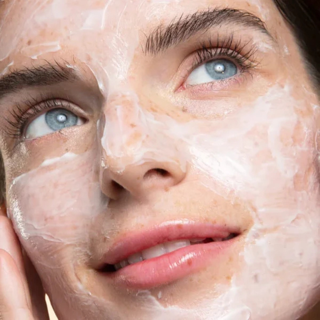 Close-up of a person with a face mask applied, focusing on the eyes and nose.