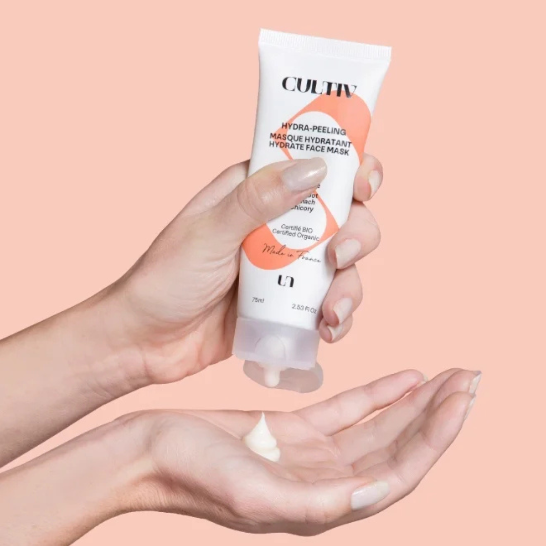Hand holding a Cultiv Hydra-peeling against a pink background