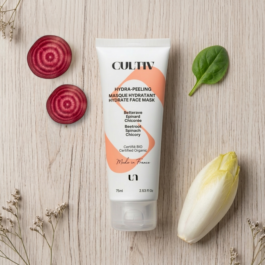 Cultiv face mask tube with beetroot, chicory, and spinach on a wooden surface